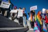 Demonstrators gather at a rally to protest the passing of anti-trans bills at the Kentucky State Capitol. They hold signs that read 